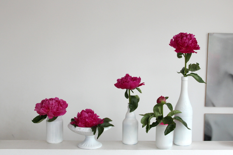 lila Pfingstrosen in weißen Vasen